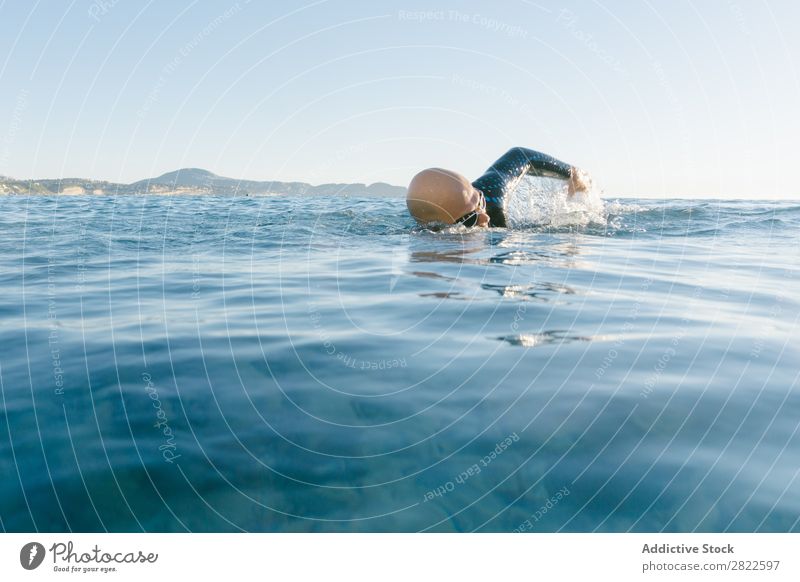 Man in wetsuit swimming in ocean Wetsuit Swimming Ocean Sports Athlete Aquatics Movement Action Water Vacation & Travel Rowing Leisure and hobbies Sunlight