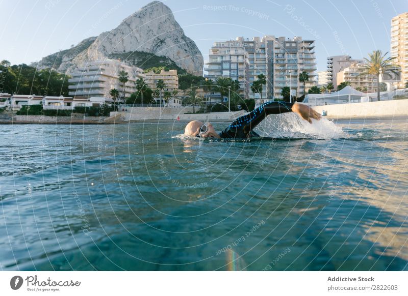 Man in wetsuit swimming in ocean Wetsuit Swimming Ocean Sports Athlete Aquatics Movement Action Water Vacation & Travel Rowing Leisure and hobbies Sunlight