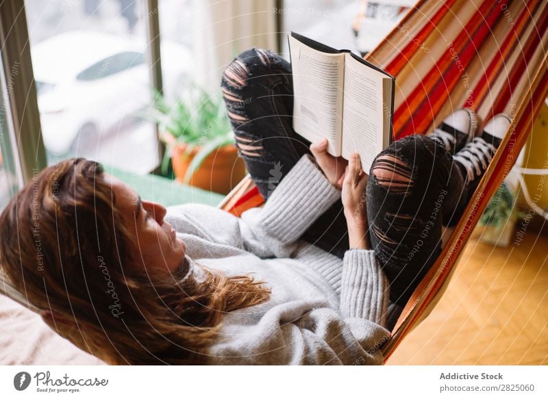 Cheerful woman lying with book Woman Home Relaxation Lie (Untruth) Hammock Reading Book Literature Lifestyle Beautiful Room Human being Easygoing Adults