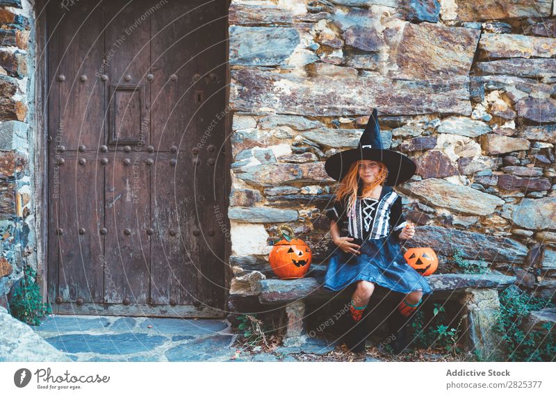 Little girl in witch costume sitting on bench Girl Hallowe'en Candy Bench Dog food Vacation & Travel Entertainment Festival Seasons Costume Tradition Sweet