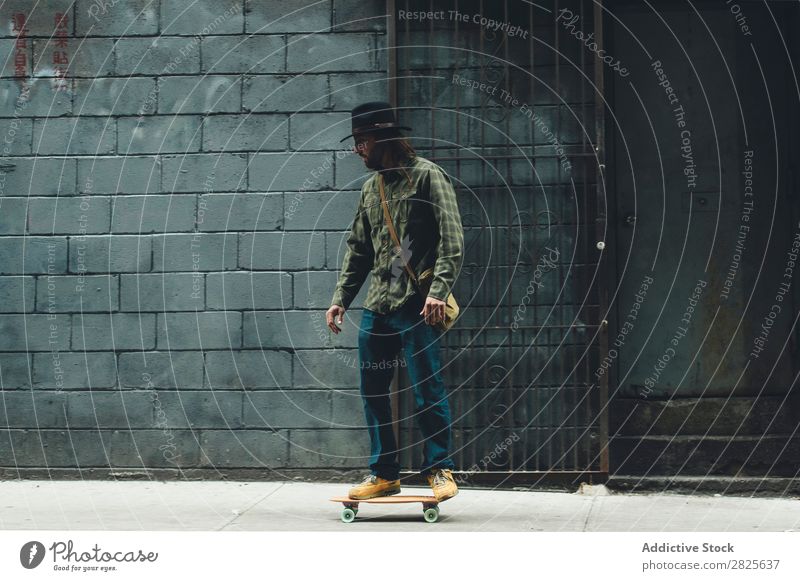 Man riding skateboard in the city Skateboard Street Stand Copy Space Cool (slang) Self-confident Hat bearded Earnest Brutal Beard Human being City Hipster
