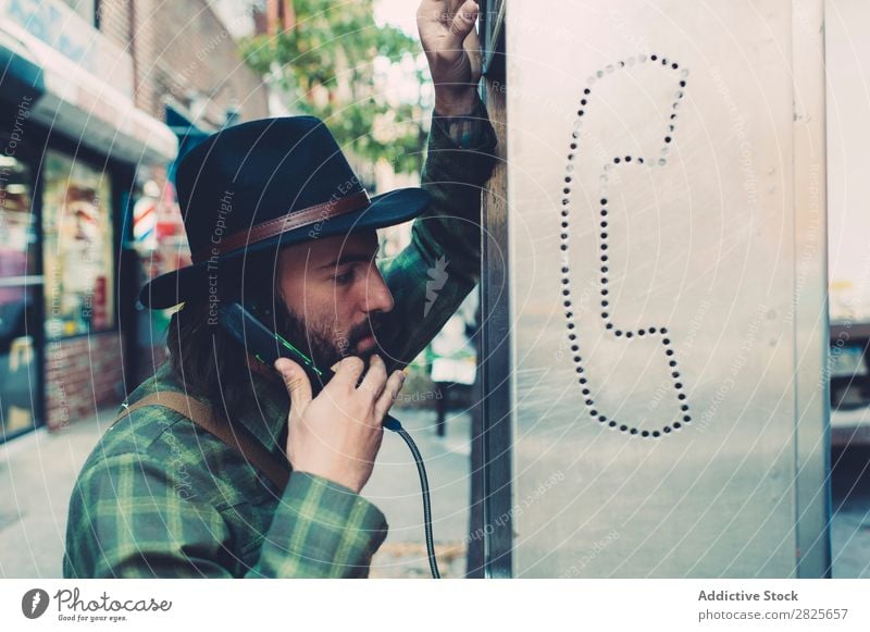 Handsome man talking on pay telephone coinbox To talk To call someone (telephone) Man Hat bearded Self-confident Earnest Street Brutal Beard Human being City