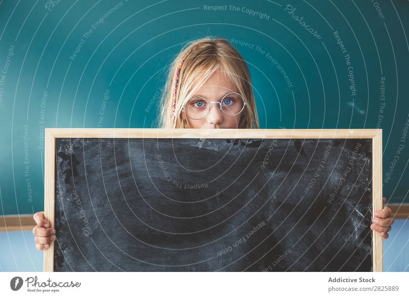 Girl holding blackboard in classroom Classroom Blackboard Stand Hold Cute Education School Grade (school level) Student Youth (Young adults) Study Child Lessons