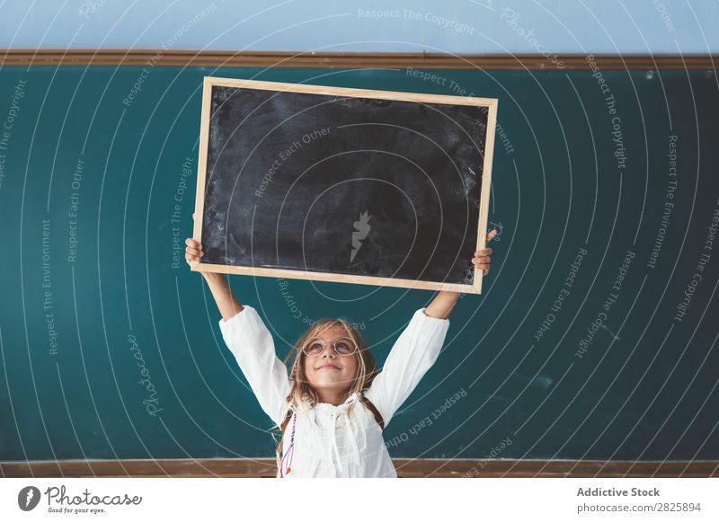 Happy girl standing with chalkboard Girl Classroom Blackboard Stand Hold Scream over head Cheerful Cute Education School Grade (school level) Student
