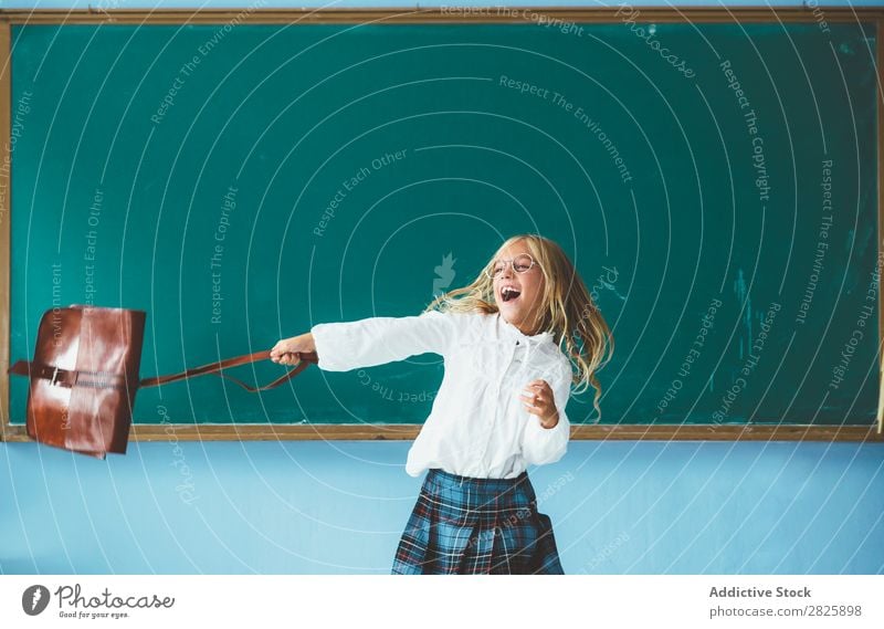 Girl throwing backpack in classroom Classroom Blackboard Joy Backpack Vacation & Travel Happy Cheerful Stand Cute Education School Grade (school level) Student