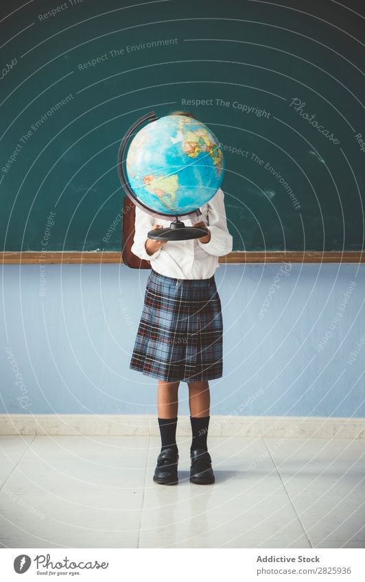 Schoolgirl covering face with globe Girl Classroom Globe Geography Cute Education Grade (school level) Student Youth (Young adults) Study Child Lessons learn