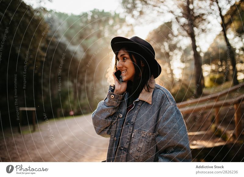 Indian woman using a phone in a countryside road Woman Telephone To talk Tourist Forest Portrait photograph Street Technology Autumn Youth (Young adults) Sunset