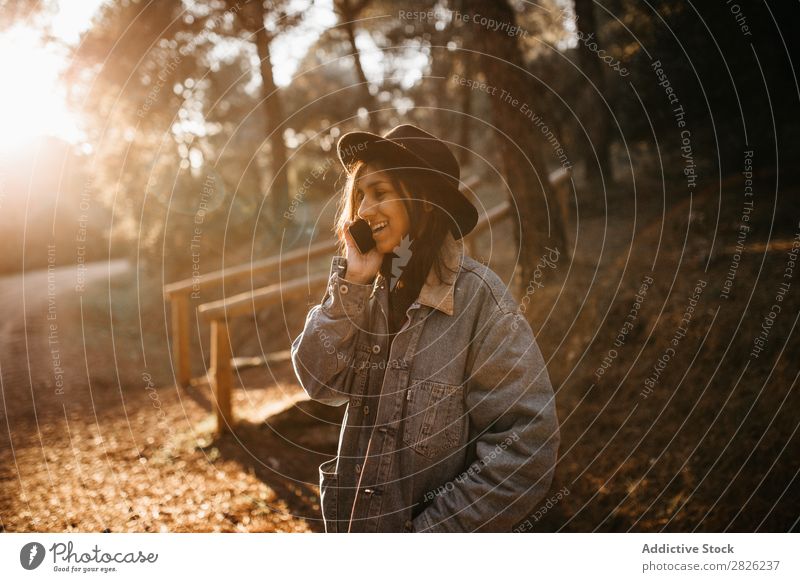 Woman talking phone on road Telephone To talk Tourist Forest Portrait photograph Street Technology Autumn Youth (Young adults) Sunset Rural Nature Silent Stand