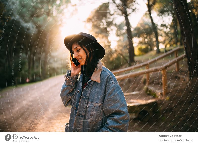Indian woman using a phone in a countryside road Woman Telephone To talk Tourist Forest Portrait photograph Street Technology Autumn Youth (Young adults) Sunset