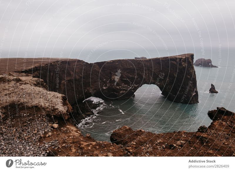 Icelandic nature wonder Man Rock Ocean Hand Height Outstretched Landscape Vantage point Coast Gloomy scenery Extreme seaside Adventure Nature Mountain