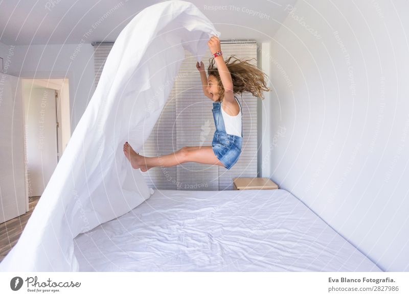 beautiful kid girl playing and jumping on bed Lifestyle Joy Happy Beautiful Leisure and hobbies Playing Reading Summer Bedroom Child Human being Feminine Baby