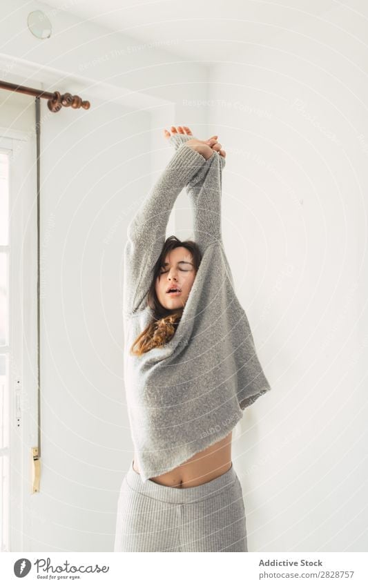 Woman taking off clothes at home pretty Youth (Young adults) Beautiful Stretching eyes closed Hands up! undressing Gray Clothing Brunette Attractive Human being