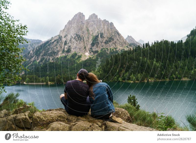 Friends sitting at lake in mountains Woman Man Mountain Together Joy Hiking Lake Water embracing Happy Vacation & Travel Adventure Tourist Youth (Young adults)
