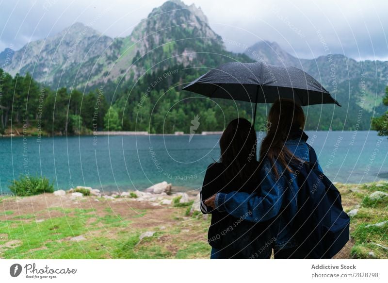 Women under umbrella in mountains Woman Mountain Together Stand Hiking Lake Water Umbrella Rain Cheerful Happy Vacation & Travel Adventure Tourist