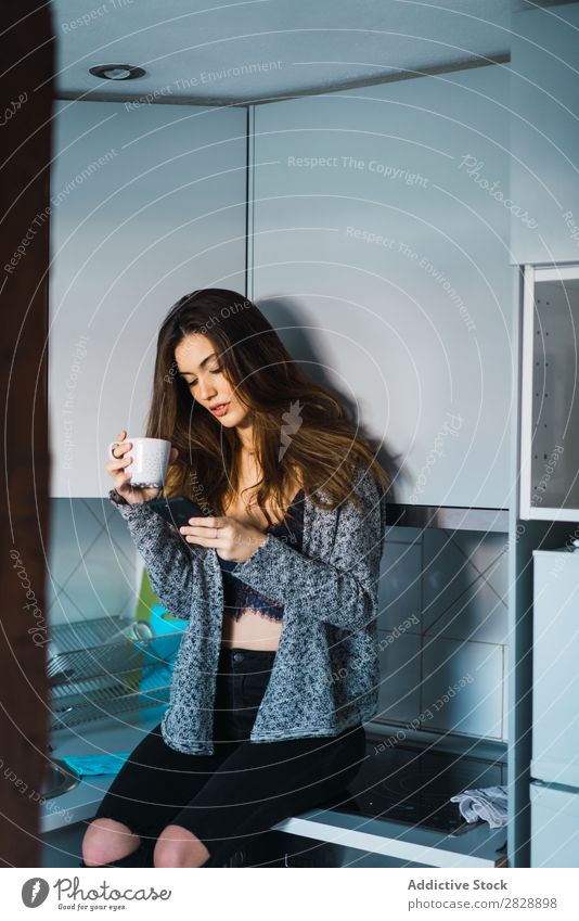 Beautiful model with cup of coffee and smartphone Woman Home Cuddling Coffee Dream human face Posture Cup Pensive Considerate Lifestyle
