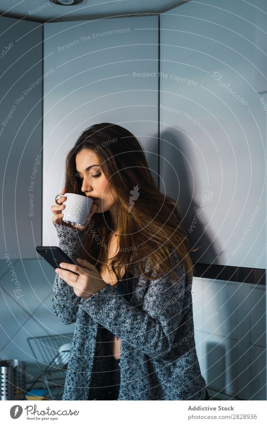 Beautiful model with cup of coffee and smartphone Woman Home Cuddling Coffee Dream human face Posture Cup Pensive Lifestyle House (Residential Structure)