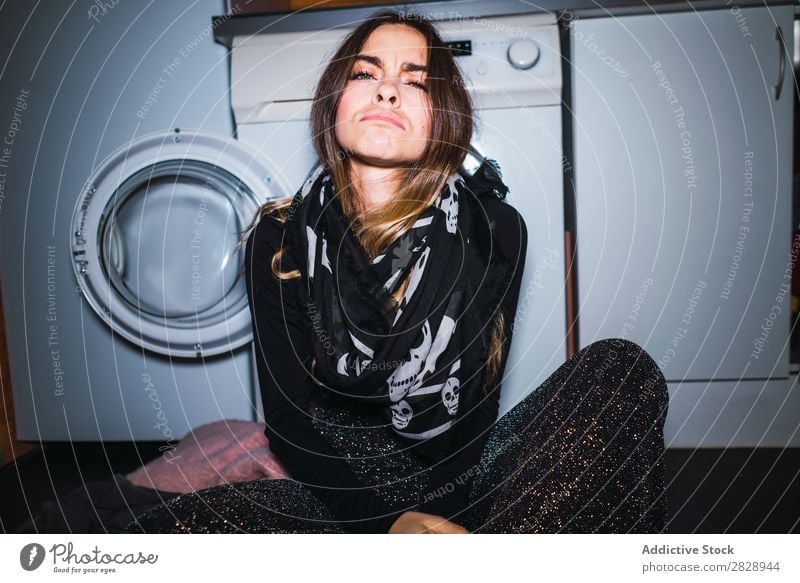 Woman sitting at laundry machine pretty Posture Home Laundry Clothing Sit Kitchen Beautiful Lifestyle Youth (Young adults) Human being Happy Attractive