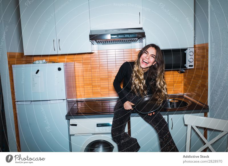 Woman sitting on kitchen table with pan pretty Posture Home Sit Table Kitchen Looking into the camera Beautiful Lifestyle Youth (Young adults) Human being Happy