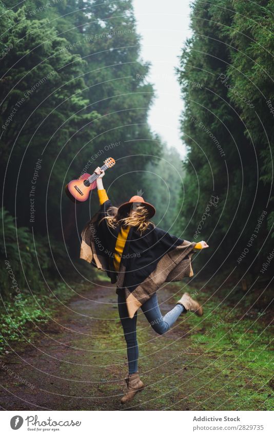 Jumping woman with ukulele in woods Woman Forest Happiness Freedom Fog Ukulele traveler Expression Excitement Movement romantic Energy Trip Cold above ground