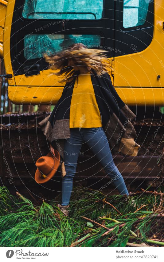 Woman posing against tractor in woods Forest Style Landscape Rock'n'Roll Tractor Gesture Rural Provocative covering face Cold Equipment Action Expression Rebel