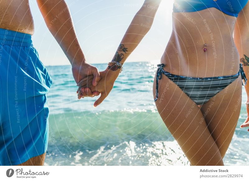 Crop couple in swimsuit holding hands Couple Ocean Honeymoon Happiness Posture Love Freedom Traveling Summer Hand Relaxation Leisure and hobbies 2 Together