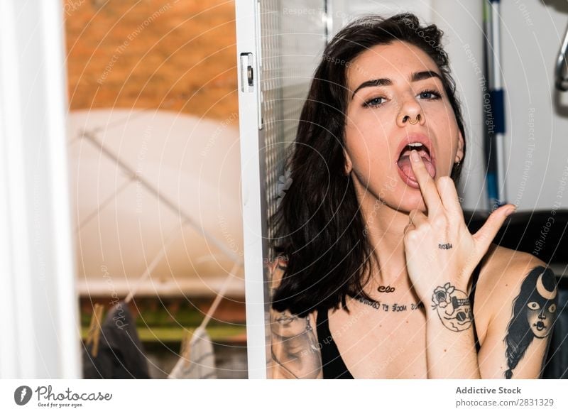 Woman with open mouth showing middle finger Offensive Gesture Portrait photograph Middle finger Indicate Expressive Interior shot rude Lick Fingers Sex Bed