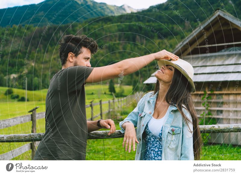 Man putting hand on woman Couple Hat Hill putting on Nature Summer Human being Woman Love Grass Beautiful Together Youth (Young adults) Happy Landscape