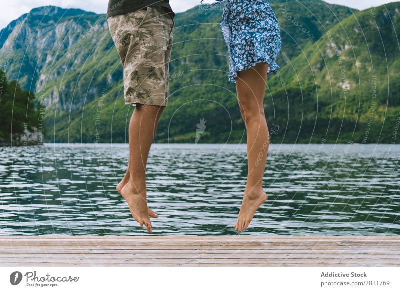 Crop couple posing on pier Couple Jetty Joy Lake Mountain Jump Happy Love Together Nature Summer Water Youth (Young adults) Woman Vacation & Travel Lifestyle