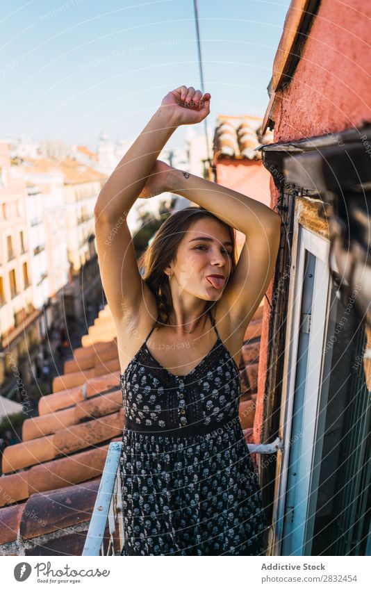 Content model grimacing on balcony Woman Cheerful romantic Happiness Grimace showing tongue Skyline Balcony Terrace Posture Expression Beauty Photography