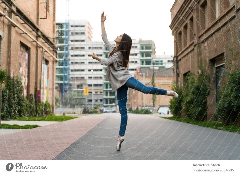 Horizontal outdoors shot of a woman in the street performing a ballet. dance concept city urban girl female dancer ballerina elegance beautiful performance