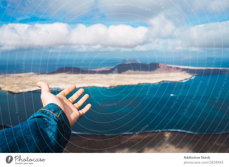 Hand showing beautiful seascape Tourist Indicate Ocean Island Clouds Aircraft Nature Landscape Natural Rock Stone Blue Lanzarote Spain Vantage point