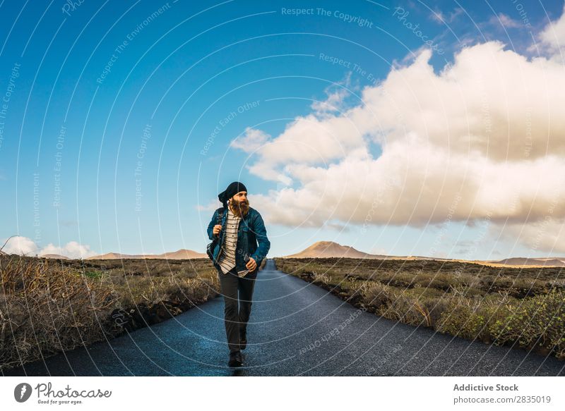 Man walking on road in field Tourist Field Walking Mountain Dry Clouds Nature Landscape Natural Rock Stone Lanzarote Spain Vantage point Vacation & Travel