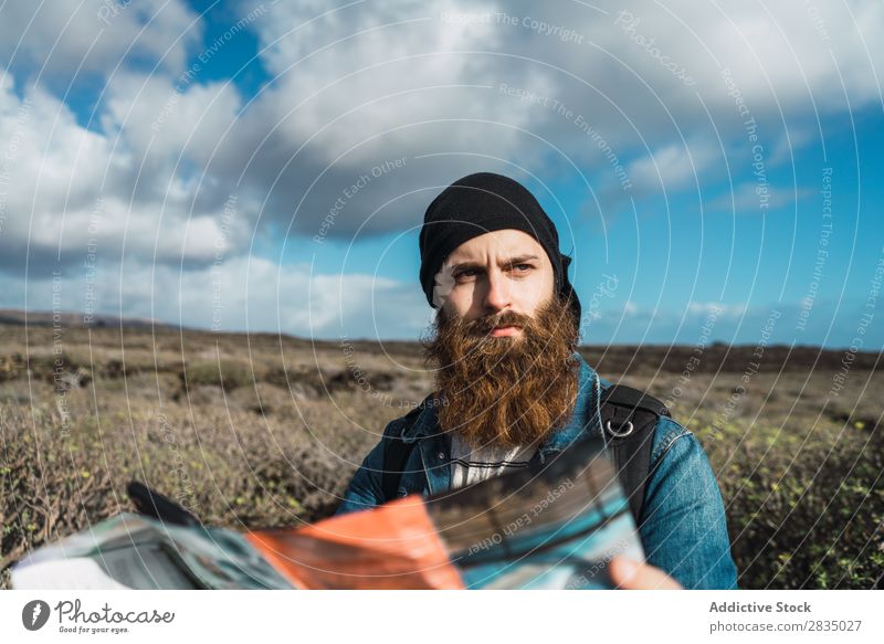 Tourist man with map and smartphone Field Map Navigation Lost Backpack Stand Rest Clouds Nature Landscape Natural Lanzarote Spain Vantage point
