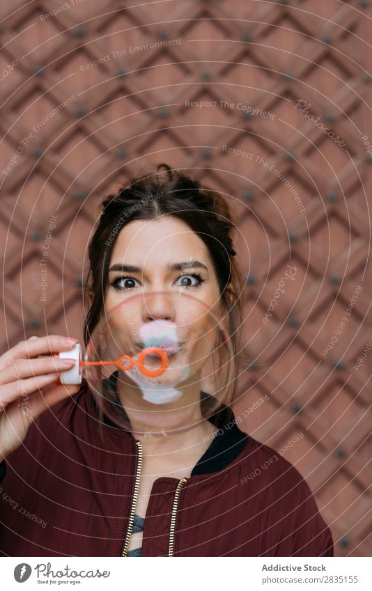 Surprised woman blowing bubbles Bubble Blow Woman surprised Brick Easygoing Wall (building) Happy Human being Hold Caucasian Youth (Young adults) Adults