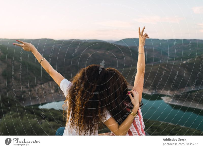 Stylish women sitting on rock in breathtaking landscape Woman Nature Mountain Point in time Cheerful Panorama (Format) Summer Wanderlust having fun Posture