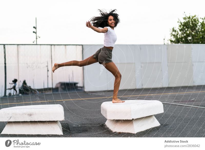 Cheerful woman jumping Woman pretty Youth (Young adults) Jump Athletic blocks Concrete gymnastic Happy Portrait photograph Looking into the camera Black African