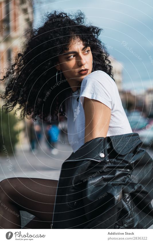 Curly woman posing in city Woman Attractive City fashionable Brunette Looking away Jacket Fence Fashion Youth (Young adults) Beautiful pretty Street Model Style