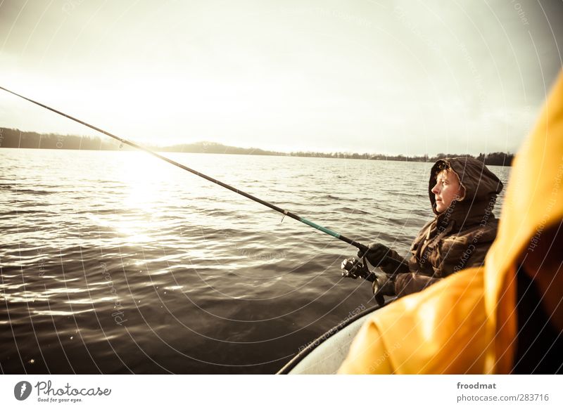 Young man fishing on the lake, the sun is low, the wind has died down, the  fish should bite - a Royalty Free Stock Photo from Photocase