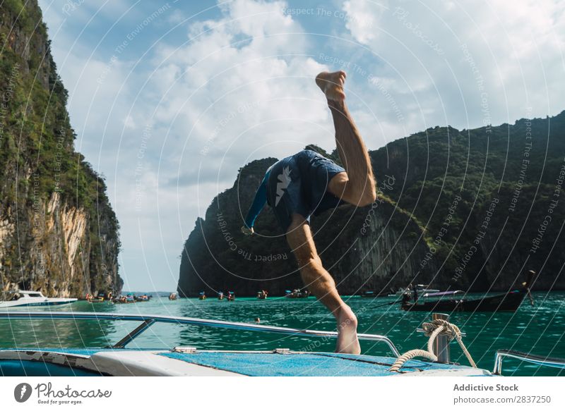 Man jumping from boat Watercraft Jump Ocean Dive Vacation & Travel Joy Summer Youth (Young adults) Yacht Adventure Cruise Sail Sailboat Sunbeam Rock