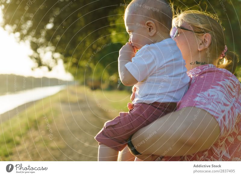 Mother holding kid on hands in park Child Park Sunbeam Family & Relations Happy Human being Woman Happiness Summer Lifestyle Love Parents Nature