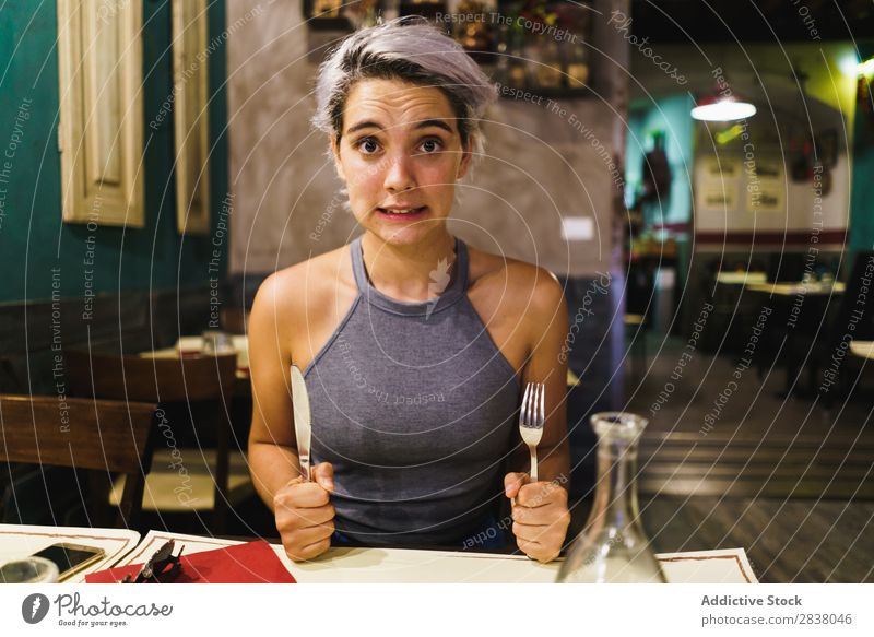 Furious girl posing with silverware Woman Restaurant Appetite having fun Expression facial Emotions humorous hysterical Anger Café Table Adults Stress pretend