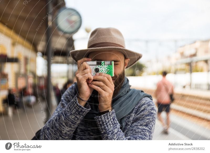 Man taking shots on small camera Photographer Easygoing Tourism Railroad Station Vacation & Travel Camera Tourist traveler Aim focusing Photography Lifestyle