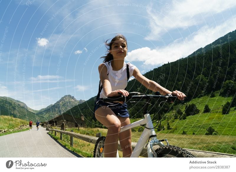 Woman riding bike looking at camera - a Royalty Free Stock Photo from  Photocase