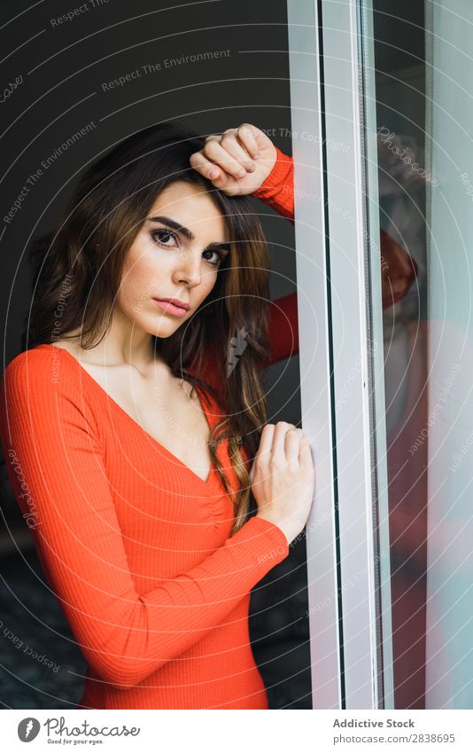 Pretty woman leaning on window Woman Home pretty Window Lean Looking into the camera Orange Dress Youth (Young adults) Posture Relaxation Portrait photograph