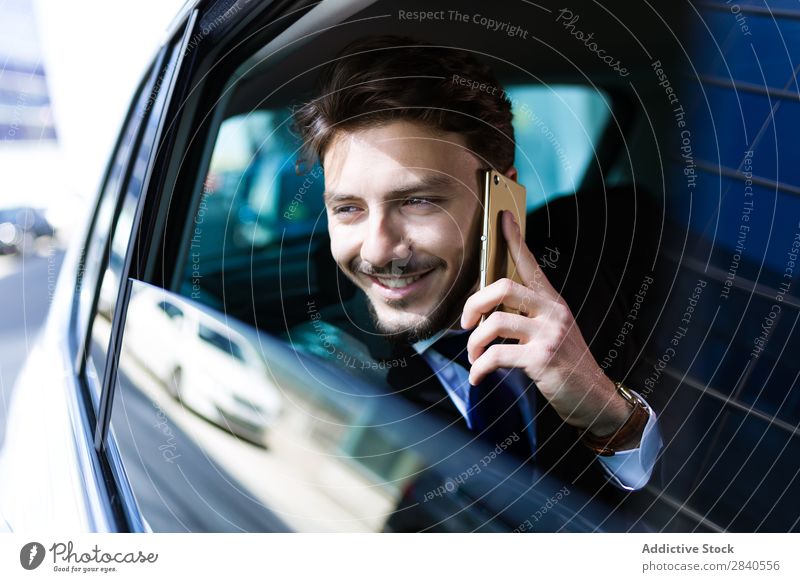 Smiling businessman talking phone in car Man Businessman Car Success Cheerful Work and employment PDA Communication using Internet Adults backseat Successful