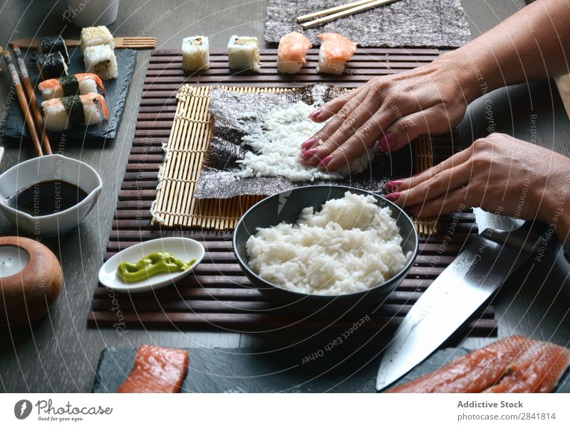 Woman preparing sushi rolls at home Sushi Make Hand Food Rice Preparation maki Chopstick oriental Cooking Mat Seaweed Roll Gourmet Seafood chef East Cucumber