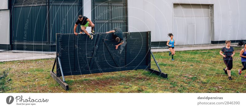 Participants in obstacle course running and climbing wall Lifestyle Sports Climbing Mountaineering Internet Human being Woman Adults Man Group Jump Authentic