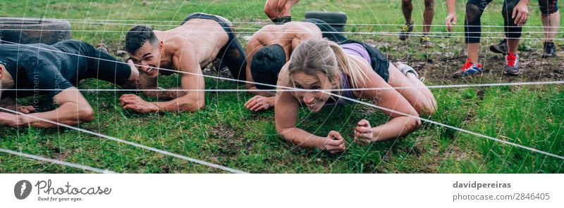 Participants in an obstacle course crawling Joy Happy Sports Internet Human being Woman Adults Man Group Dirty Black Effort Competition Barbed wire