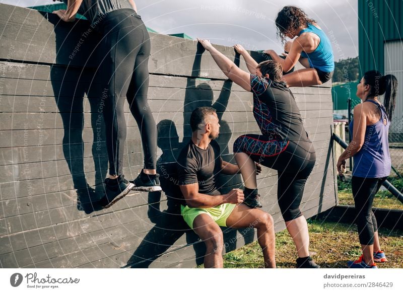 Group in obstacle course climbing wall Lifestyle Sports Climbing Mountaineering Human being Woman Adults Man Authentic Black Effort Competition Teamwork