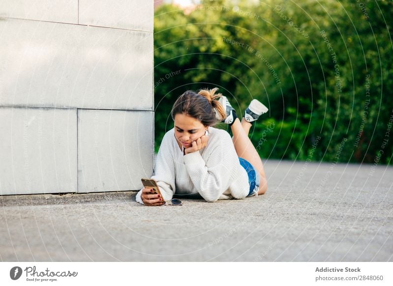 Girl browsing phone while lying on ground Woman Youth (Young adults) PDA youngster Technology Internet Connection Culture leaning on hand using Hipster Summer